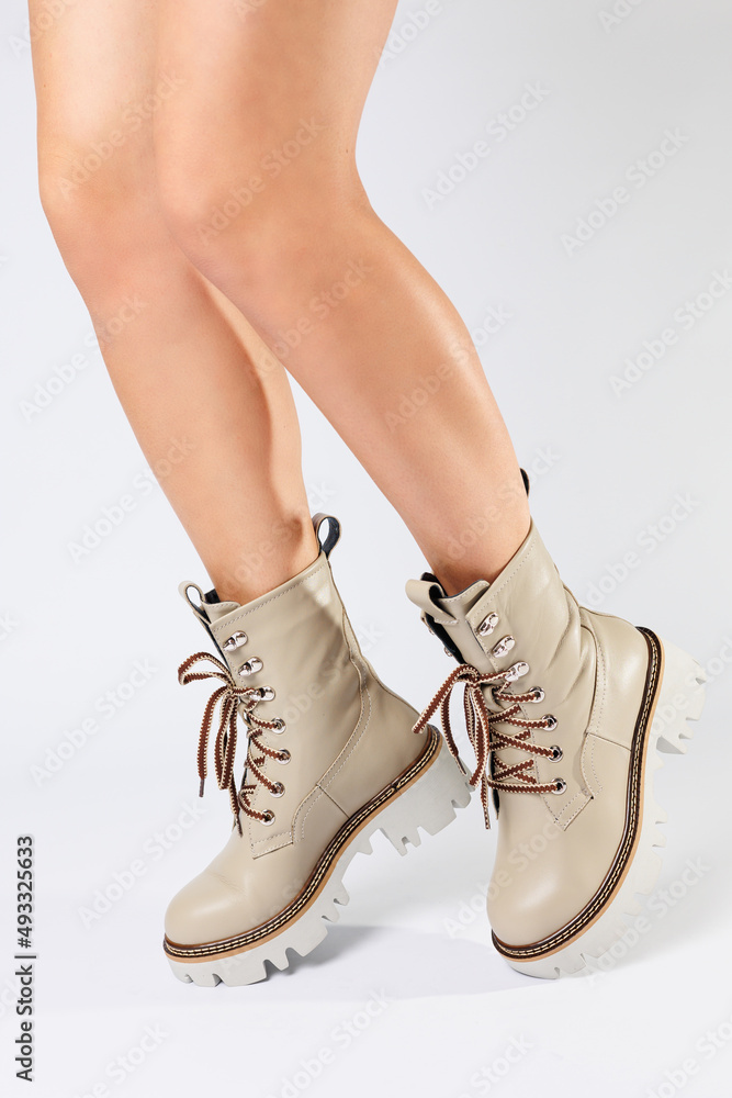 Women's white spring boots made of genuine leather are worn on a woman's leg. New collection of women's boots 2022 Women's white spring boots made of genuine leather are worn on a woman's leg. New collection of women's boots 2022
