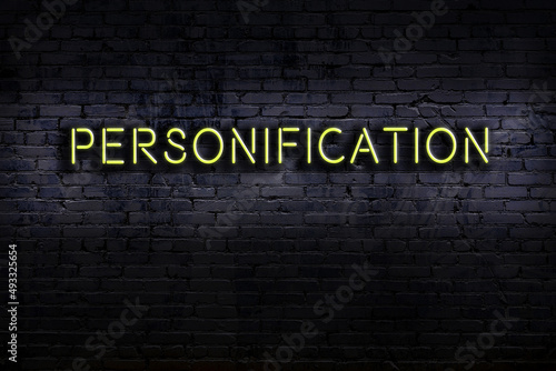 Night view of neon sign on brick wall with inscription personification