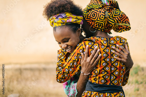 Cheerful African girls hugging on street photo