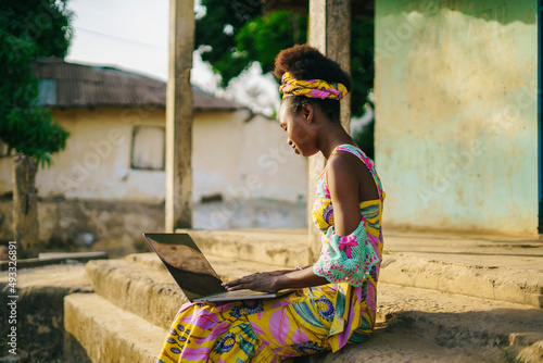 Local girl surfing laptop in countryside village photo