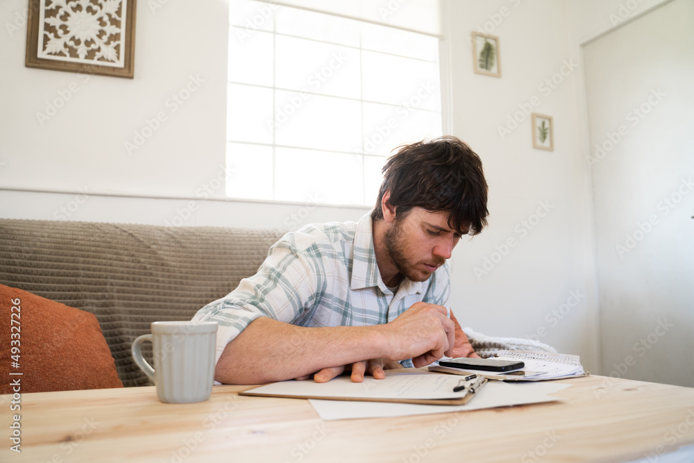 Focused man calculating bills on phone Focused man calculating bills on phone