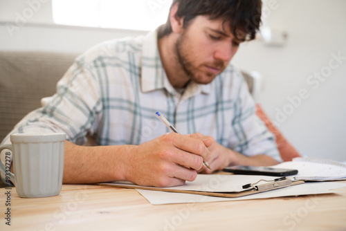 Focused man doing paperwork and bill payments photo