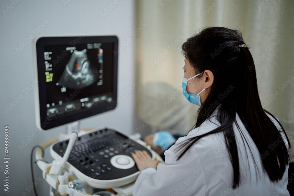 Female Chinese obstetrician performs an ultrasound Stock Photo | Adobe ...