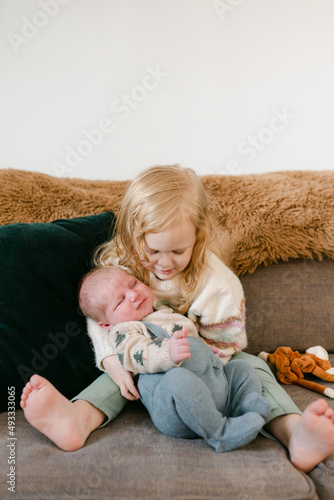 big sister holding newborn  photo