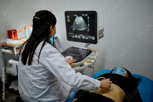 Female Chinese obstetrician performs an ultrasound 