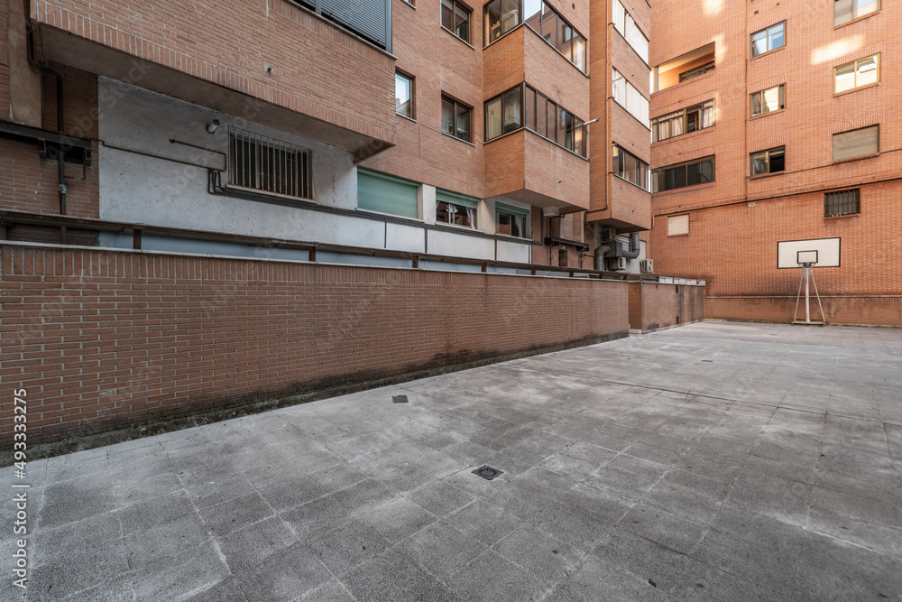 Collective courtyard of an urban residential housing building with a basketball hoop