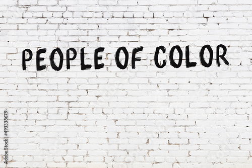 White wall with black paint inscription people of color on it