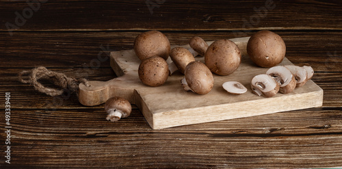 Brown button mushroom (Agaricus brunnescens) on a cutting board photo