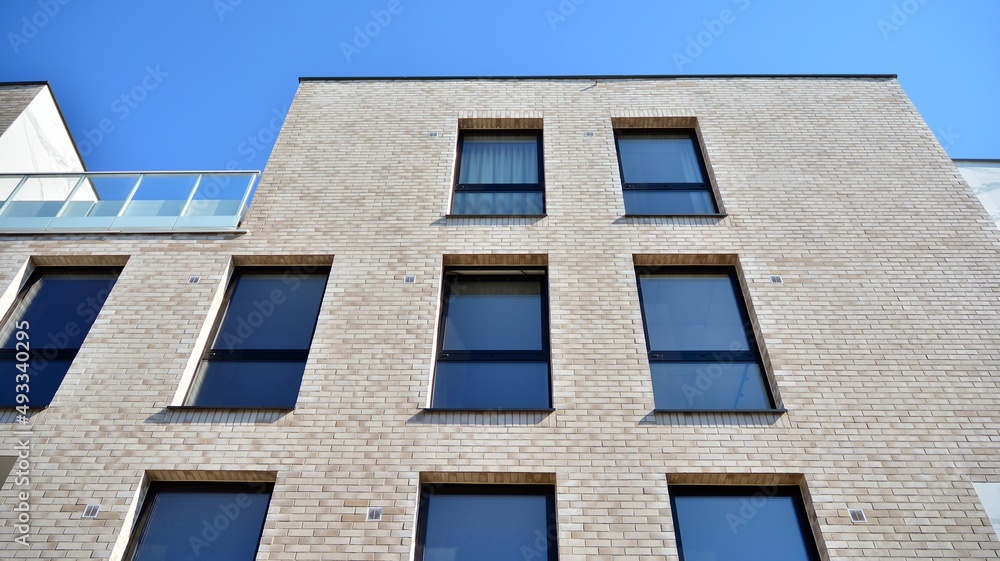 Obraz premium Modern european residential architecture on a sunny day. Exterior of new multi-story residential building. Concept of sale and rental of apartments for consumers .Modern windows and balconies.