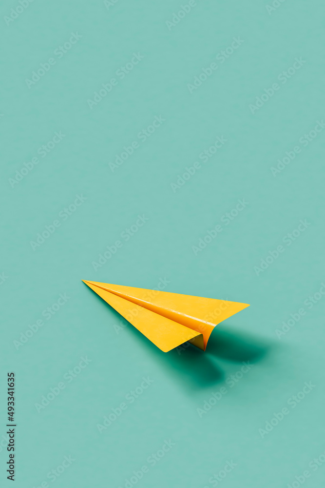 Yellow paper plane on blue background with copy space Yellow paper plane on blue background with copy space