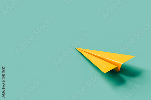yellow paper plane on blue background photo