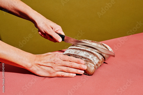 man about to cut a rye bread loaf photo
