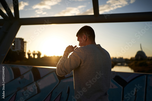Sportsman in fighting stance on bridge in evening