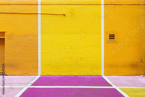 yellow wall on the street with white lines