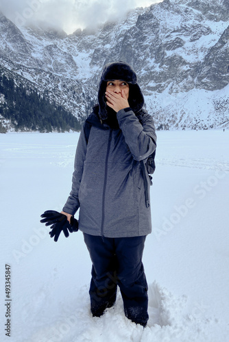 Surprised Woman Standing In Snow In Mountains  photo