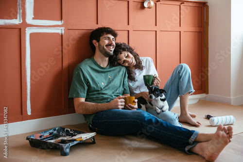 Cheerful couple with dog in renovated room photo
