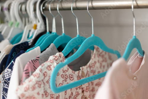 Baby and little girl clothes on hanger photo