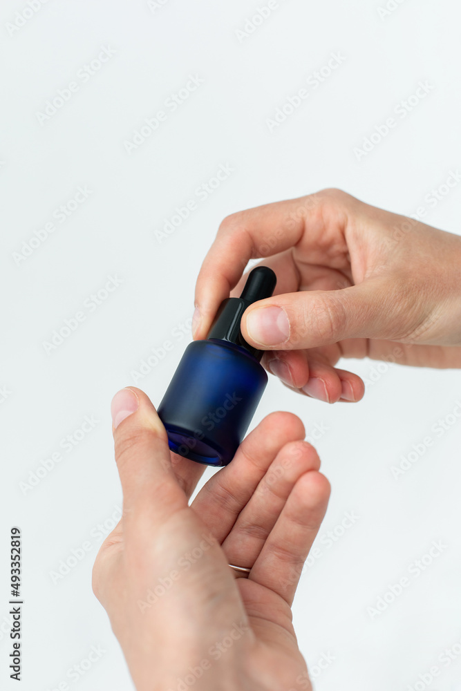 Essential cosmetic glass bottle in hands Essential cosmetic glass bottle in hands