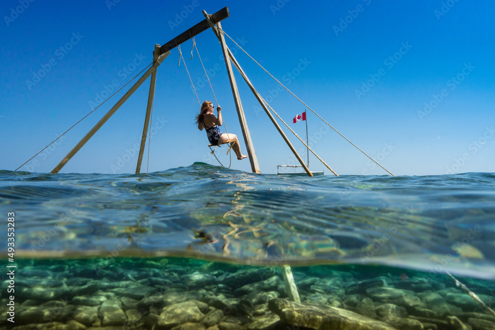Woman with One Piece Bathing Suit Sitting on Lake Swing Woman with One Piece Bathing Suit Sitting on Lake Swing