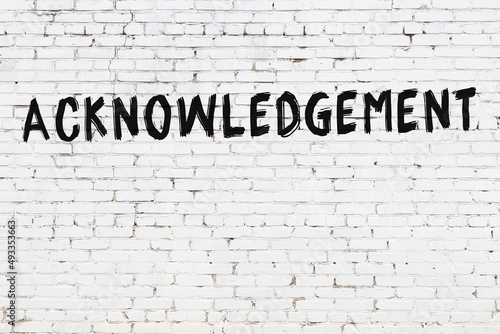 Inscription acknowledgement painted on white brick wall