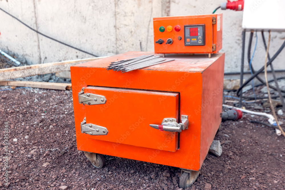 View of the basic electrode and flux dryer or oven in the construction site. Manufacturers of electrodes specify desired temperature and time for drying the electrodes prior to use. View of the basic electrode and flux dryer or oven in the construction site. Manufacturers of electrodes specify desired temperature and time for drying the electrodes prior to use.