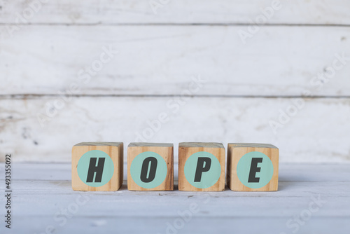 hope concept written on wooden cubes or blocks, on white wood background. © Dionisio