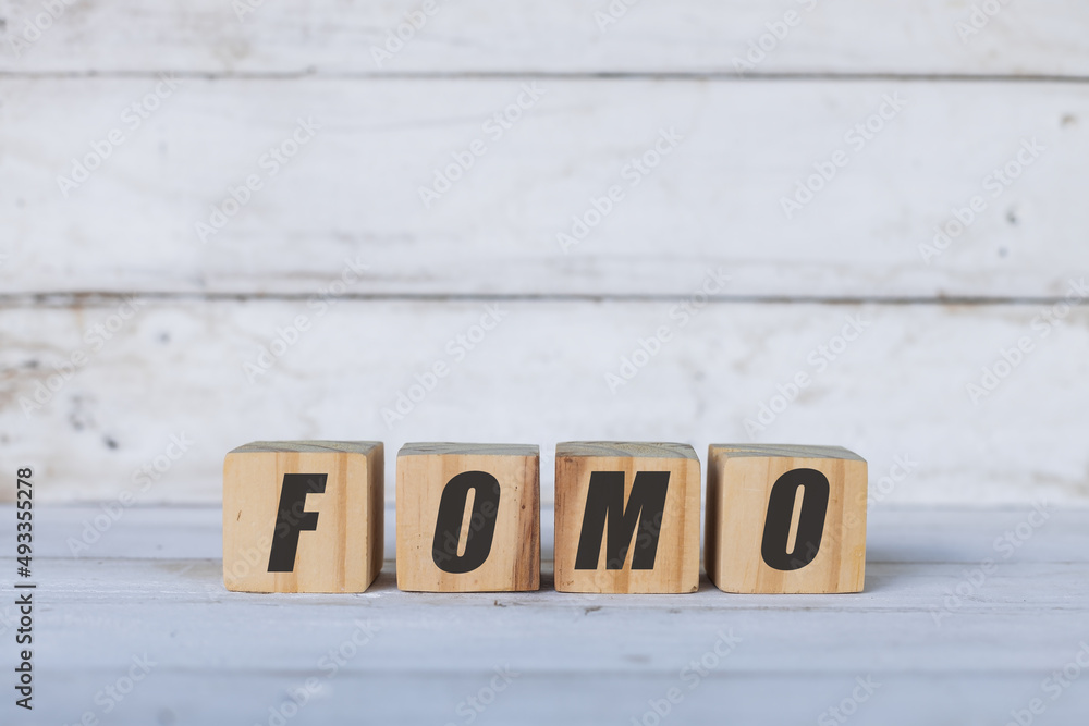 FOMO concept written on wooden cubes or blocks, on white wooden background. FOMO concept written on wooden cubes or blocks, on white wooden background.