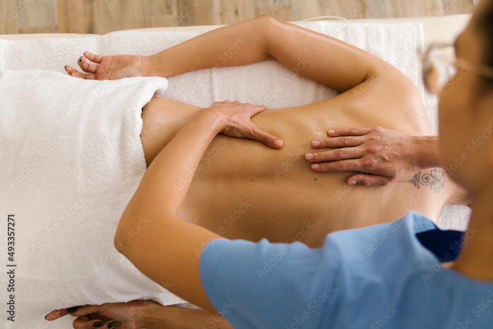 Masseuse massaging a client at spa Masseuse massaging a client at spa
