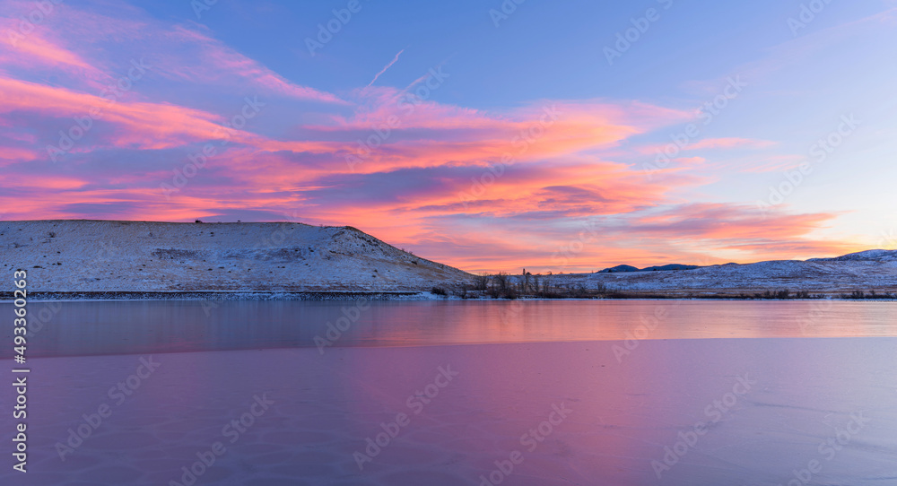 Sunset Bear Creek Lake - A colorful Winter sunset view of frozen Bear Creek Lake, with Mount Carbon raising at shore. Bear Creek Lake Park, Denver-Lakewood-Morrison, Colorado, USA.