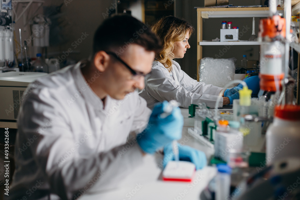 Scientists working with molecular samples in DNA lab Scientists working with molecular samples in DNA lab