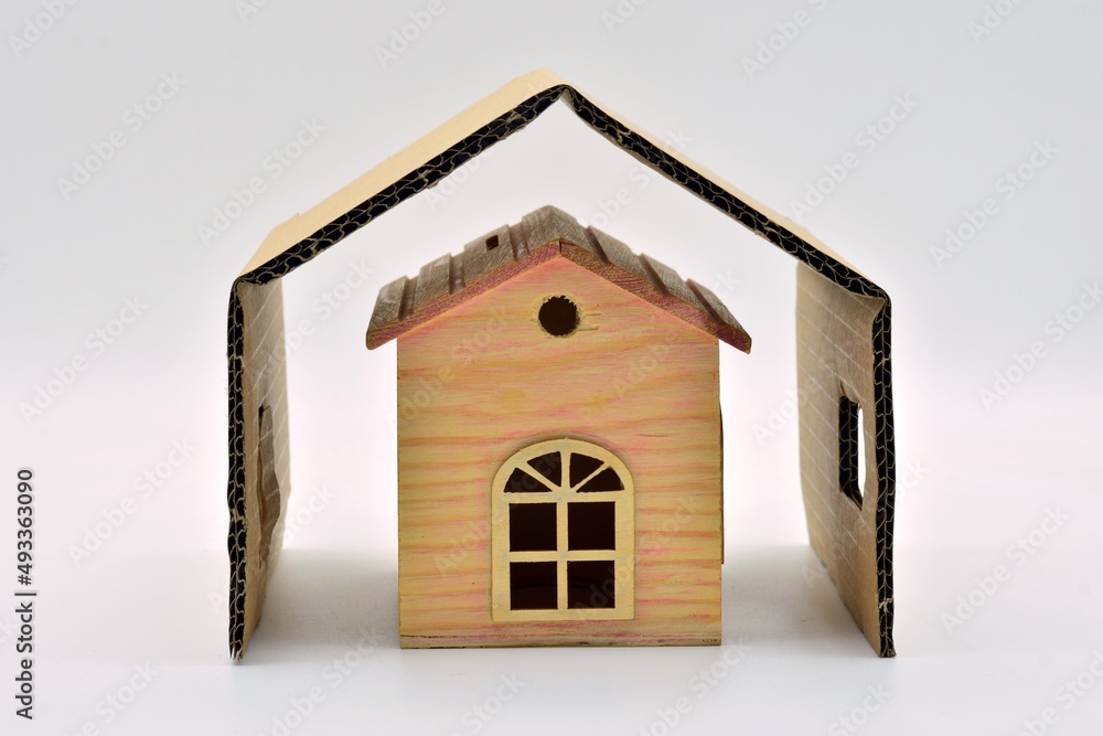 Casita de madera en miniatura protegida por una cubierta exterior, aislado en blanco Casita de madera en miniatura protegida por una cubierta exterior, aislado en blanco