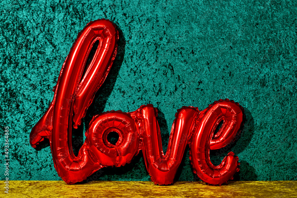 © Juan Moyano/Stocksy - red balloon in the shape of the word love