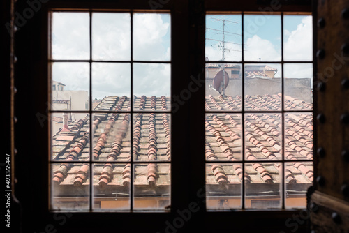 Red tiled roof through a closed window photo