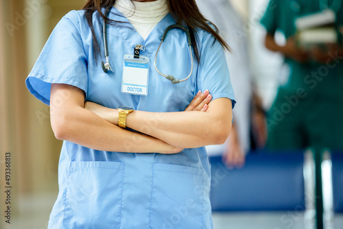 Close up half body, woman doctor wear blue uniform hang stethoscope arms crossed at hospital. Healthy and medical concept.