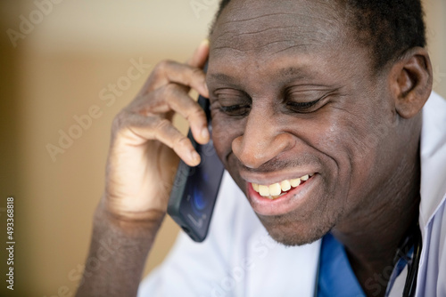 Close up African American medical male doctor talking with mobile phone.