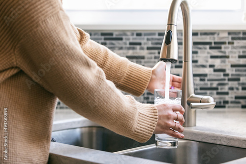 Kitchen: Woman Uses Automatic Sensor Faucet photo