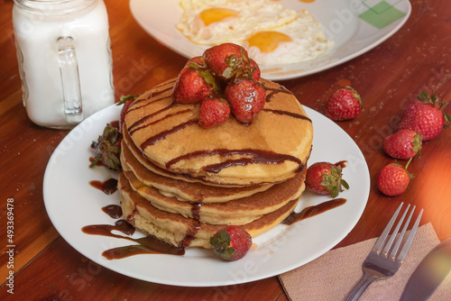 Plate of hot cakes and strawberries on a table