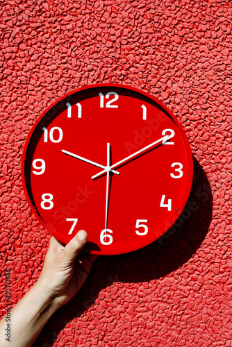 man with a red clock in his hand photo