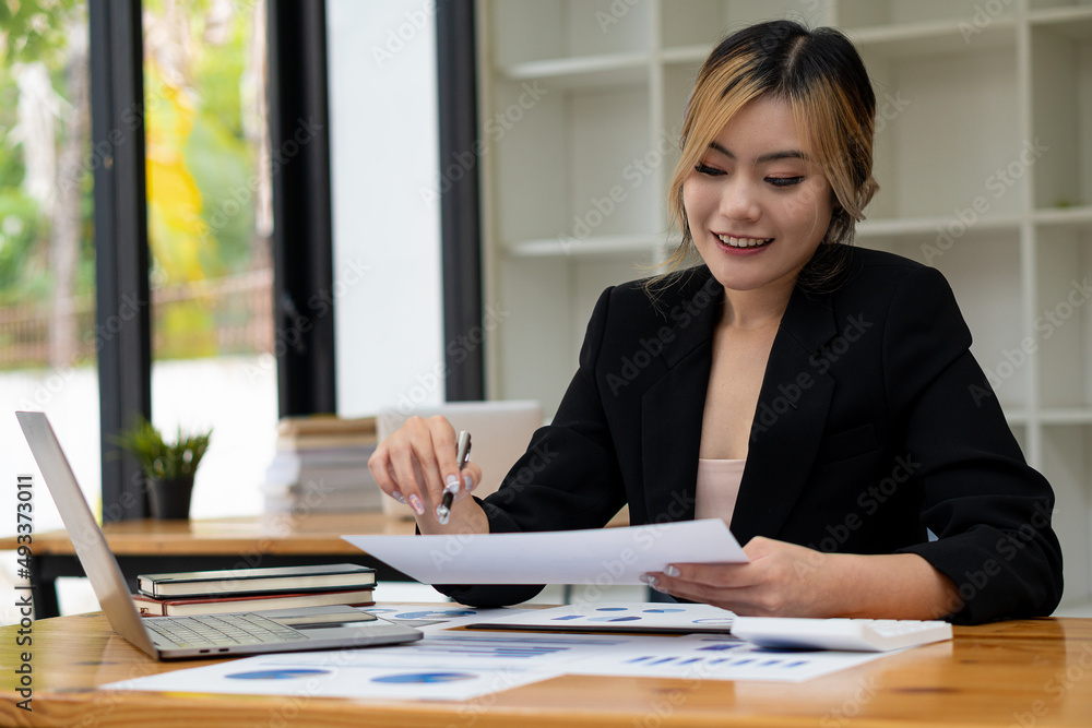 Asian businesswoman using the laptop and working at the modern desk and paperwork Asian woman planning financial report analysis business plan investment financial analysis concept Asian businesswoman using the laptop and working at the modern desk and paperwork Asian woman planning financial report analysis business plan investment financial analysis concept