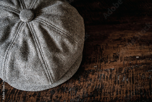 Detail of a classic eight-panel newsboy hat in tweed fabric herringbone in khaki on a classic electronic background photo