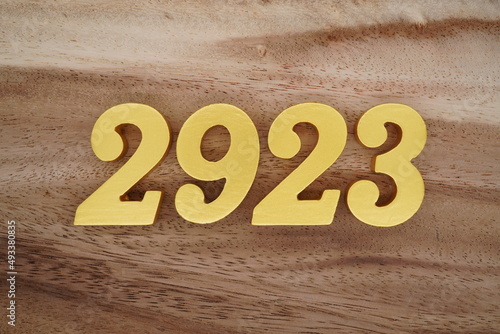 Foto Golden Arabic numerals on a real brown and white wooden floor number 2923