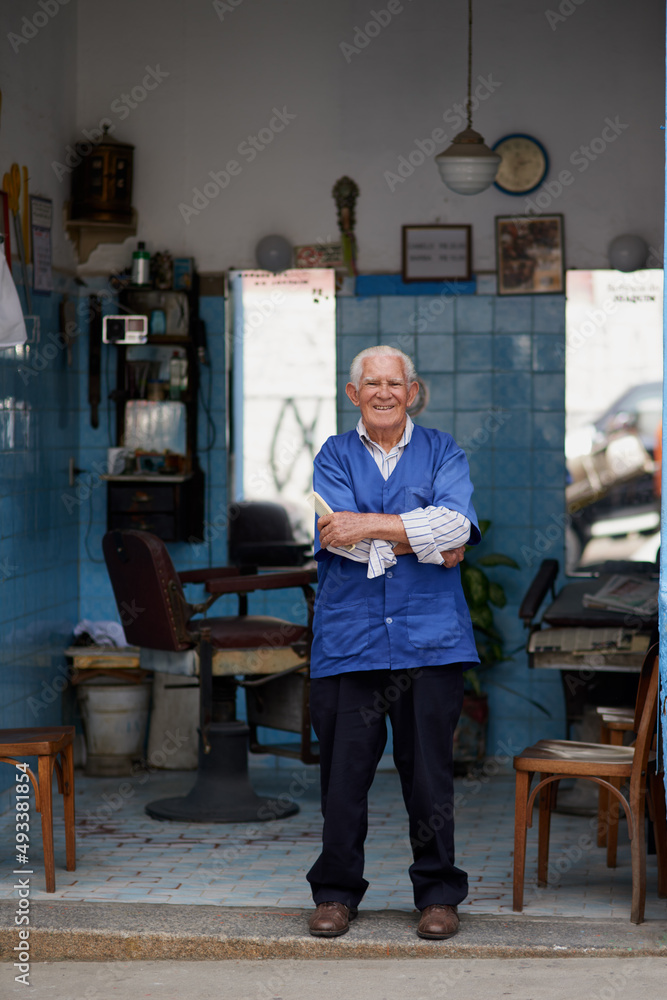 He knows everything feels better after a haircut. Shot of a senior man in his barber shop.