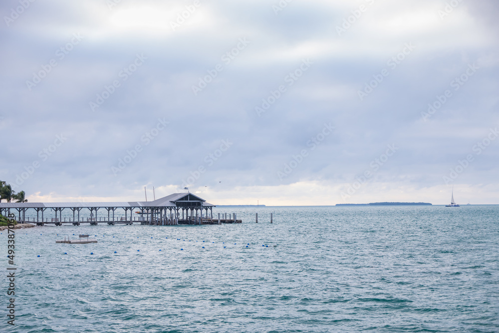 Obraz premium Boathouse and pier, storm clouds background