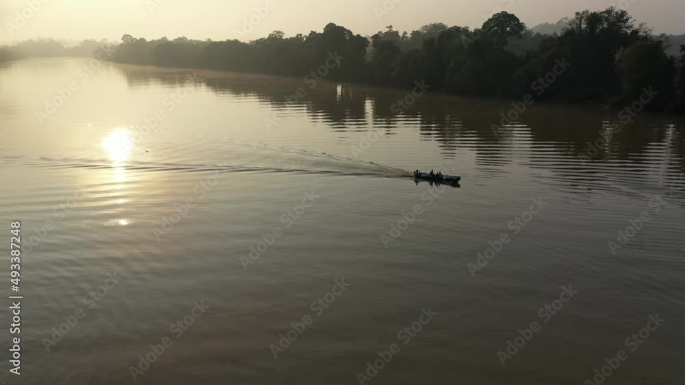 Drone sunset view of Fisherman passing by on kinabatangan river Drone sunset view of Fisherman passing by on kinabatangan river