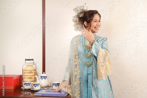 Beautiful young woman wearing Mahsuri style Baju Kebaya Labuh traditional malay Malaysian dress fashion photo