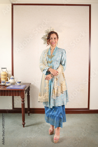 Beautiful young woman wearing Mahsuri style Baju Kebaya Labuh traditional malay Malaysian dress fashion