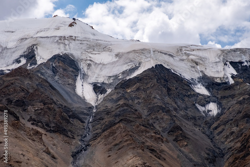 Glacier on rocky mountains. Melting glaciers due to global warming climate change problem. Barskoon mountain pass. Travel tourism in Kyrgyzstan concept. © Adil