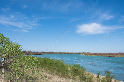 Ili river in spring time. Beautiful river with blue water and sky. Wild nature landscape background.