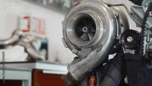 Pan up on a large turbocharger mounted on a half finished race engine.
