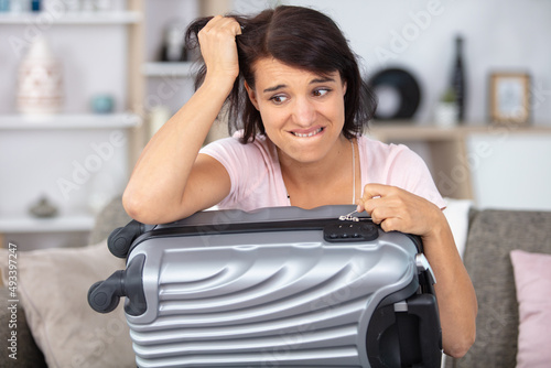 Fotografie troubled woman has forgotten the code for her suitcase lock
